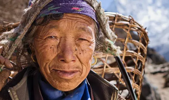 Nepalese woman carrying basket in mountains