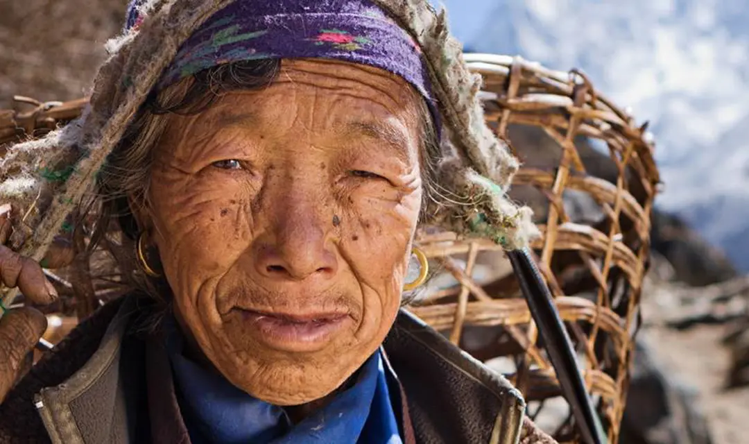 Nepalese woman carrying basket in mountains