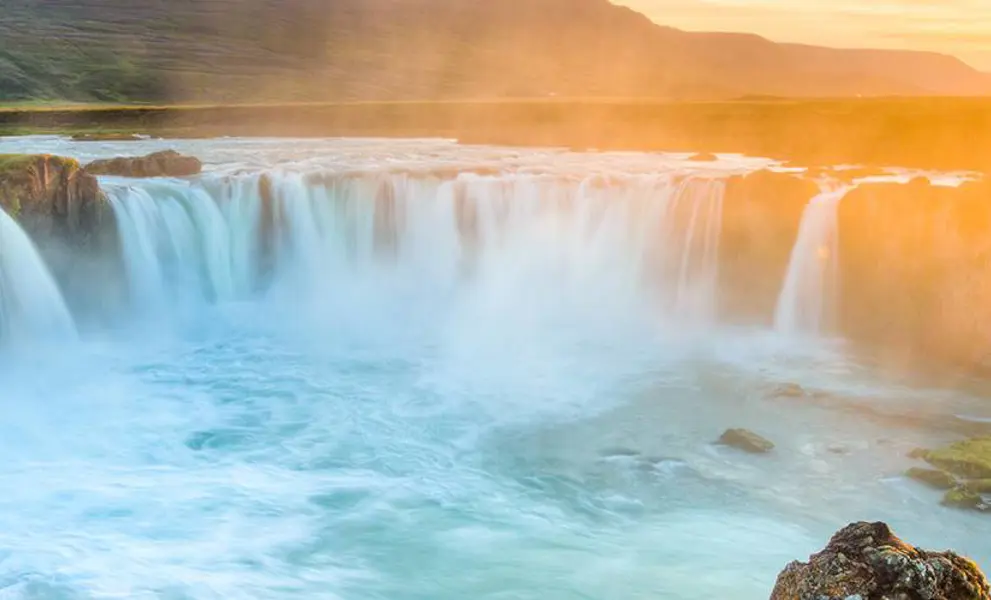 Sun setting over an Icelandic waterfall